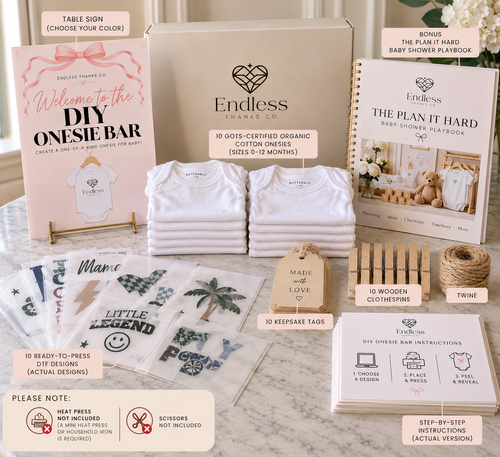 A DIY onesie bar bundle by Endless Thanes Co. arranged on a marble surface, including a kraft table sign, a large storage box, folded white baby clothes, wooden clothes hangers, twine, sticker sheets, and printed instruction cards and booklets.