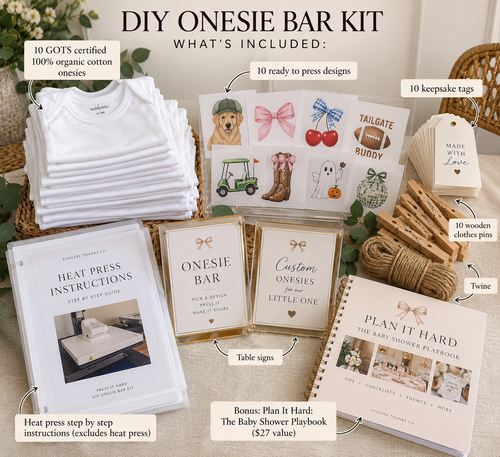 DIY Onesie Bar Kit bundle displayed on a styled tabletop with labeled callouts showing included items: a stack of white cotton onesies, printed onesie bar cards, wooden clothes pins, twine, a heat press, instruction booklet, and a bonus baby shower playbook.