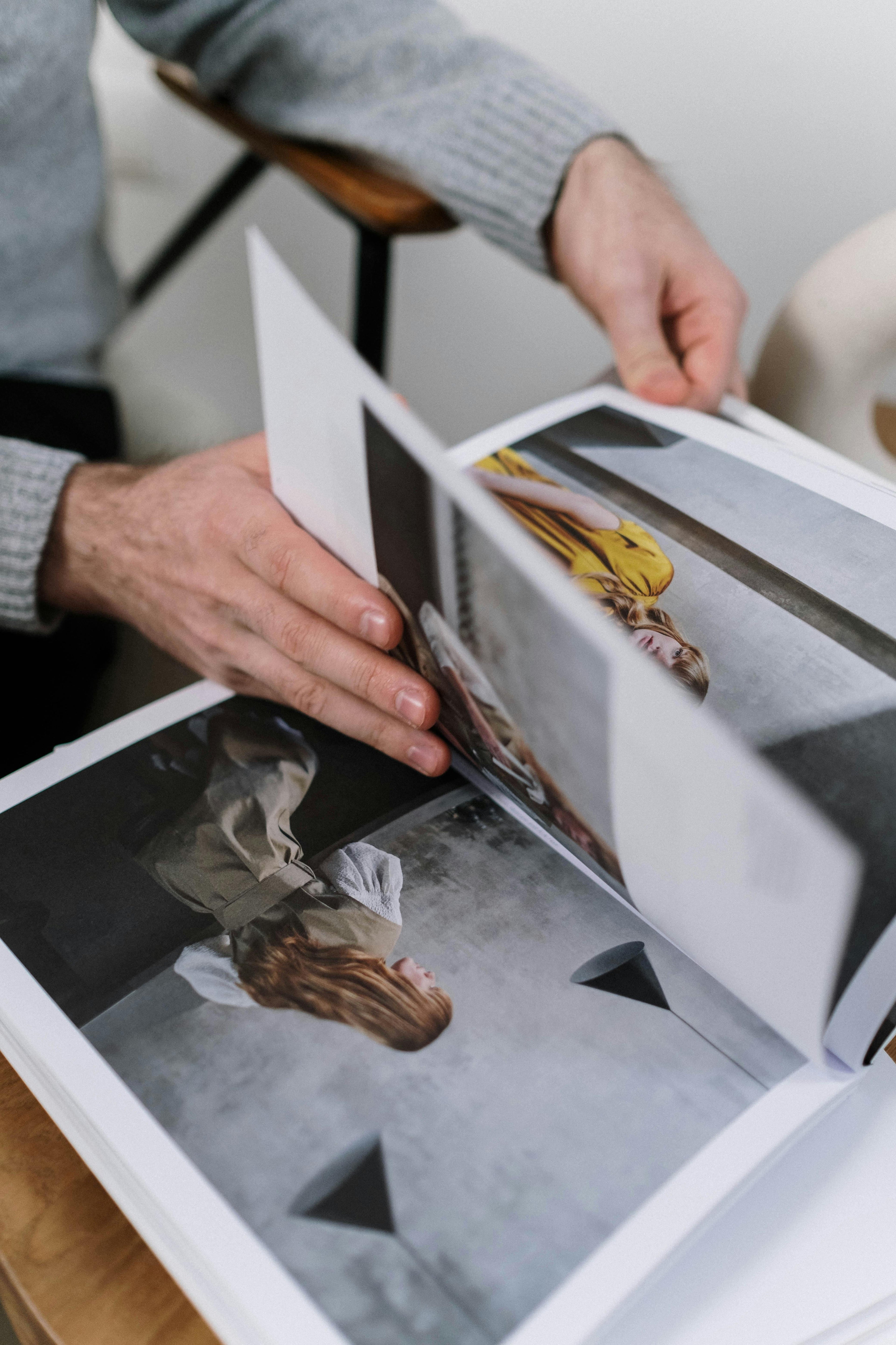 Person holding an open photo album with images of a person and a dog.